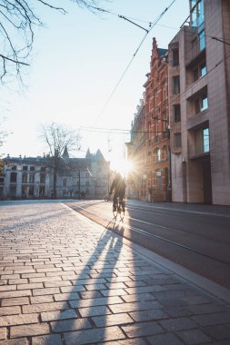 Ghent, Belçika 'nın şehir merkezinde güneş doğarken bisikletle işe koşan bir adam. Ana ulaşım aracı olarak bisikleti kullanın. Ekolojik mühendislik.