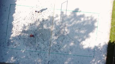 Voleybol oyuncuları plaj voleybolu oynarlar. Kazma, vurma, bloklama, pas ve taktik eğitimi. Güneşli bir günde voleybol antrenmanı