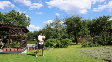 Voleybol oyuncusu, voleybol becerilerini dışarıda çimen sahasında topla çalışıyor. Pas ver, vur, kaz. Hareketin otomasyonu. Özel tatbikat