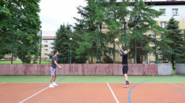 Voleybol oyuncuları dışarıda voleybol oynarlar. Kazma, vurma, bloklama, pas ve taktik eğitimi. Güneşli bir günde voleybol antrenmanı