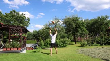 Voleybol oyuncusu, voleybol becerilerini dışarıda çimen sahasında topla çalışıyor. Pas ver, vur, kaz. Hareketin otomasyonu. Özel tatbikat