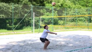 Voleybol oyuncusu voleybol sahasında bir topla voleybol antrenmanı yapıyor. Pas ver, vur, kaz. Hareketin otomasyonu. Özel tatbikat