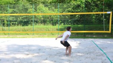 Voleybol oyuncusu voleybol sahasında bir topla voleybol antrenmanı yapıyor. Pas ver, vur, kaz. Hareketin otomasyonu. Özel tatbikat