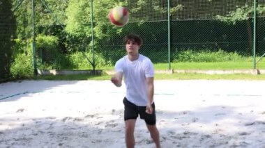 Voleybol oyuncusu voleybol sahasında bir topla voleybol antrenmanı yapıyor. Pas ver, vur, kaz. Hareketin otomasyonu. Özel tatbikat