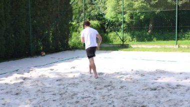 Voleybol oyuncusu voleybol sahasında bir topla voleybol antrenmanı yapıyor. Pas ver, vur, kaz. Hareketin otomasyonu. Özel tatbikat