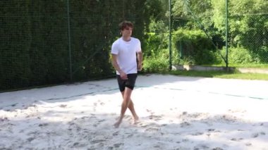 Voleybol oyuncusu voleybol sahasında bir topla voleybol antrenmanı yapıyor. Pas ver, vur, kaz. Hareketin otomasyonu. Özel tatbikat