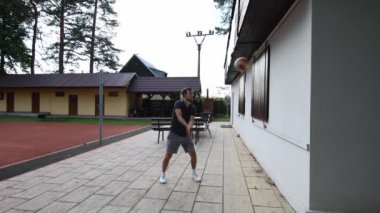 Voleybol oyuncusu duvarda bir topla voleybol antrenmanı yapıyor. Pas ver, vur, kaz. Hareketin otomasyonu. Özel tatbikat