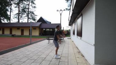 Voleybol oyuncusu duvarda bir topla voleybol antrenmanı yapıyor. Pas ver, vur, kaz. Hareketin otomasyonu. Özel tatbikat