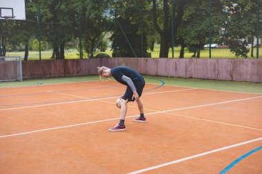 Basketbolcu, sahanın dışında oynanan sıradan bir maçta topu kontrol ediyor ve top sürüyor, odak noktasına eğiliyor. Saray ağaçlar ve doğa ile çevrili. Huzurlu ve atletik bir atmosfer sağlıyor..