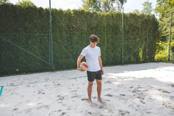 Voleybol oyuncusu, bir top tutuyor ve bir sonraki oyuna hazırlanıyor. Açık deniz voleybolu maçında..