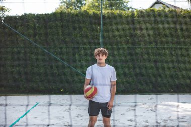 Voleybol oyuncusu, bir top tutuyor ve bir sonraki oyuna hazırlanıyor. Açık deniz voleybolu maçında..