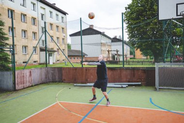 Voleybol oyuncusu açık hava antrenmanı sırasında sert bir kortu pas geçiyor. Eylem, rastgele bir oyun ayarında odak, hareket ve top kontrolünü yakalar.
