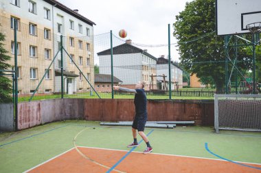 Voleybol oyuncusu açık hava antrenmanı sırasında sert bir kortu pas geçiyor. Eylem, rastgele bir oyun ayarında odak, hareket ve top kontrolünü yakalar.