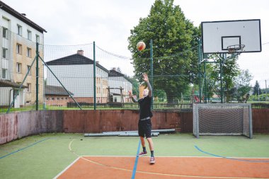 Voleybol oyuncusu bir açık hava maçı sırasında sert bir sahada görev yapıyor. Hareket, dinamik bir voleybol ortamında atletizm, çeviklik ve kontrol gösteriyor..