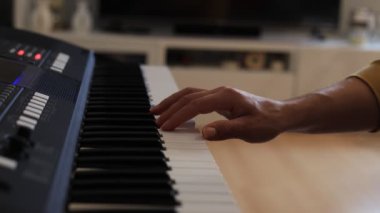 Müzisyen elleri rahatça dijital bir klavyenin üzerinde süzülerek rahat bir ev ortamında beceri ve hassasiyet sergiliyor. Video yaratıcılığı ve müzikal tutkuyu vurguluyor