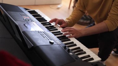 Müzisyen elleri rahatça dijital bir klavyenin üzerinde süzülerek rahat bir ev ortamında beceri ve hassasiyet sergiliyor. Video yaratıcılığı ve müzikal tutkuyu vurguluyor
