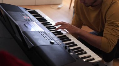 Müzisyen elleri rahatça dijital bir klavyenin üzerinde süzülerek rahat bir ev ortamında beceri ve hassasiyet sergiliyor. Video yaratıcılığı ve müzikal tutkuyu vurguluyor