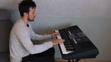 Müzisyen elleri rahatça dijital bir klavyenin üzerinde süzülerek rahat bir ev ortamında beceri ve hassasiyet sergiliyor. Video yaratıcılığı ve müzikal tutkuyu vurguluyor