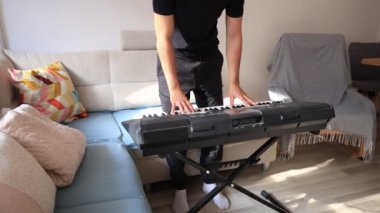 Müzisyen elleri rahatça dijital bir klavyenin üzerinde süzülerek rahat bir ev ortamında beceri ve hassasiyet sergiliyor. Video yaratıcılığı ve müzikal tutkuyu vurguluyor