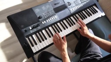 Müzisyen elleri rahatça dijital bir klavyenin üzerinde süzülerek rahat bir ev ortamında beceri ve hassasiyet sergiliyor. Video yaratıcılığı ve müzikal tutkuyu vurguluyor