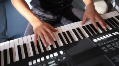 Müzisyen elleri rahatça dijital bir klavyenin üzerinde süzülerek rahat bir ev ortamında beceri ve hassasiyet sergiliyor. Video yaratıcılığı ve müzikal tutkuyu vurguluyor