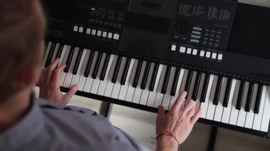 Müzisyen elleri rahatça dijital bir klavyenin üzerinde süzülerek rahat bir ev ortamında beceri ve hassasiyet sergiliyor. Video yaratıcılığı ve müzikal tutkuyu vurguluyor