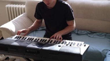 Müzisyen elleri rahatça dijital bir klavyenin üzerinde süzülerek rahat bir ev ortamında beceri ve hassasiyet sergiliyor. Video yaratıcılığı ve müzikal tutkuyu vurguluyor