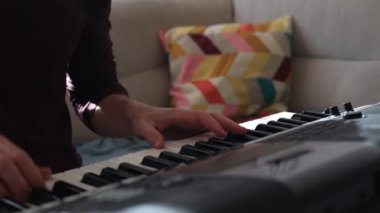 Müzisyen elleri rahatça dijital bir klavyenin üzerinde süzülerek rahat bir ev ortamında beceri ve hassasiyet sergiliyor. Video yaratıcılığı ve müzikal tutkuyu vurguluyor