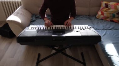 Müzisyen elleri rahatça dijital bir klavyenin üzerinde süzülerek rahat bir ev ortamında beceri ve hassasiyet sergiliyor. Video yaratıcılığı ve müzikal tutkuyu vurguluyor