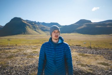 Batı İzlanda 'daki Snafellsnes Yarımadası' nda, engebeli volkanik dağlar, geniş düzlükler ve soğuk sonbahar havasıyla çevrili gezgin şehvet dolu genç bir gezgin duruyor..