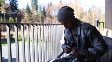 Tutkulu 26 yaşındaki müzisyen günbatımında gitar çalarak açık havada eğleniyor. Doğada olmak. Modern halk tarzında doğa ve müziğe duyulan sevginin bir karışımı. 4k video