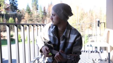 Tutkulu 26 yaşındaki müzisyen günbatımında gitar çalarak açık havada eğleniyor. Doğada olmak. Modern halk tarzında doğa ve müziğe duyulan sevginin bir karışımı. 4k video