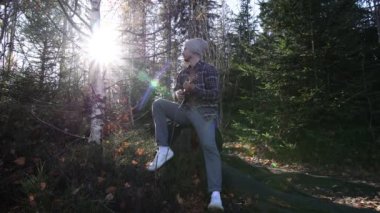 Tutkulu 26 yaşındaki müzisyen günbatımında gitar çalarak açık havada eğleniyor. Doğada olmak. Modern halk tarzında doğa ve müziğe duyulan sevginin bir karışımı. 4k video