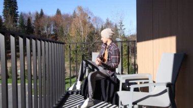 Tutkulu 26 yaşındaki müzisyen günbatımında gitar çalarak açık havada eğleniyor. Doğada olmak. Modern halk tarzında doğa ve müziğe duyulan sevginin bir karışımı. 4k video