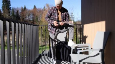 Tutkulu 26 yaşındaki müzisyen günbatımında gitar çalarak açık havada eğleniyor. Doğada olmak. Modern halk tarzında doğa ve müziğe duyulan sevginin bir karışımı. 4k video