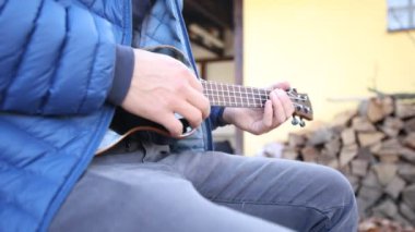 Tutkulu 26 yaşındaki müzisyen günbatımında gitar çalarak açık havada eğleniyor. Doğada olmak. Modern halk tarzında doğa ve müziğe duyulan sevginin bir karışımı. 4k video