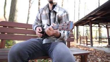 Tutkulu 26 yaşındaki müzisyen günbatımında gitar çalarak açık havada eğleniyor. Doğada olmak. Modern halk tarzında doğa ve müziğe duyulan sevginin bir karışımı. 4k video