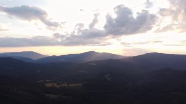 Bir dağın arkasındaki günbatımının hava manzarası manzaranın son kalıntılarını aydınlatıyor. Beskydy Dağları, Çek Cumhuriyeti.