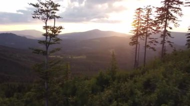 Bir dağın arkasındaki günbatımının hava manzarası manzaranın son kalıntılarını aydınlatıyor. Beskydy Dağları, Çek Cumhuriyeti.