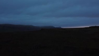 Ülkenin batısında gizlenmiş, dokunulmamış ve gizemli İzlanda manzarasının havadan görünüşü. Lav tarlaları yosunla kaplı ve içinden akan bir nehir var. 4K yatay video