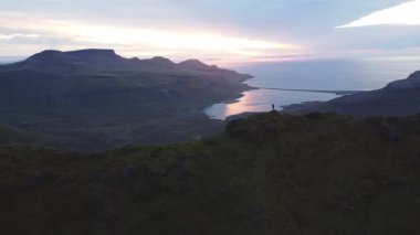 İnsanoğlu bir dağın zirvesinde duruyor, her iki tarafında sarp kayalıklarla çevrili, nefes kesen bir güneşin altın ışığı batı İzlanda 'daki Snaefellsnes Yarımadası' nı yıkıyor.