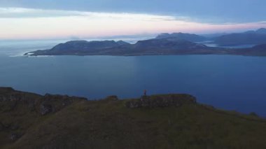 İnsanoğlu bir dağın zirvesinde duruyor, her iki tarafında sarp kayalıklarla çevrili, nefes kesen bir güneşin altın ışığı batı İzlanda 'daki Snaefellsnes Yarımadası' nı yıkıyor.