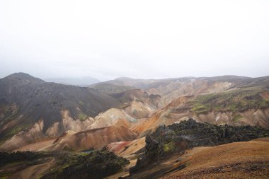 Renkli rhyolite dağlarının geniş manzarası ve İzlanda, Landmannalaugar 'da örülmüş bir nehir yatağı. İskoçya 'nın kalbinde gerçek üstü ve el değmemiş volkanik bir manzara..