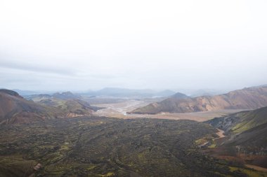 Renkli rhyolite dağlarının geniş manzarası ve İzlanda, Landmannalaugar 'da örülmüş bir nehir yatağı. İskoçya 'nın kalbinde gerçek üstü ve el değmemiş volkanik bir manzara..