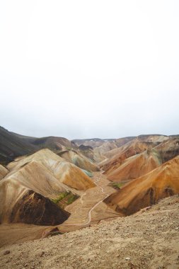 Landmannalaugar, İzlanda 'daki renkli rhyolite dağlarının ve dolambaçlı derenin manzarası. Zamanla ve ham doğal güçlerle şekillenen gerçeküstü volkanik bir manzara. Ünlü İzlanda mekanı.