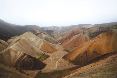 Landmannalaugar, İzlanda 'daki renkli rhyolite dağlarının ve dolambaçlı derenin manzarası. Zamanla ve ham doğal güçlerle şekillenen gerçeküstü volkanik bir manzara. Ünlü İzlanda mekanı.