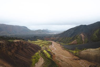 Landmannalaugar, İzlanda 'daki renkli rhyolite dağlarının ve dolambaçlı derenin manzarası. Zamanla ve ham doğal güçlerle şekillenen gerçeküstü volkanik bir manzara. Ünlü İzlanda mekanı.
