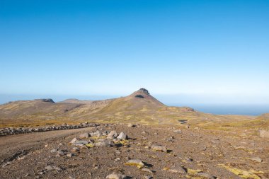 Sırt çantalı yalnız yürüyüşçü, İzlanda 'nın gerçeküstü volkanik dağlarını keşfeder. Altın yosunların karamsar kayaların altında kara lav kayalarıyla buluştuğu, el değmemiş ve destansı bir yer.