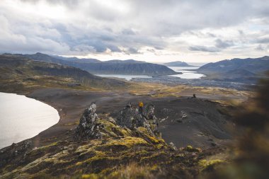 Altın güneş ışığı, İzlanda 'daki Snaefellsnes Yarımadası' ndaki Boynuz adlı dağın ufukta parlıyor. Gökyüzüne ve aşağıdaki volkanik topraklara çarpıcı bir ışık saçıyor..