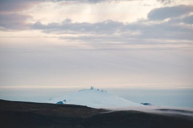 Buzul tepeli Snaefellsjokull volkanı Batı İzlanda 'daki yumuşak sabah sisinin içinden çıkarak mistik ve zamansız bir Kuzey Kutbu atmosferini anımsattı..